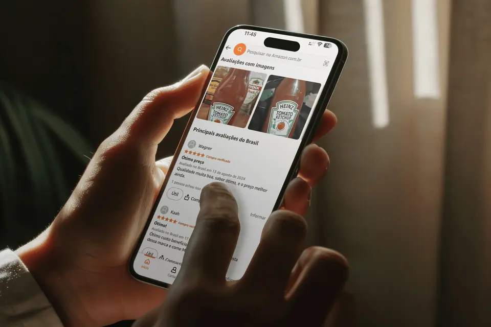 Hand holding a phone showing ketchup reviews in an online store
